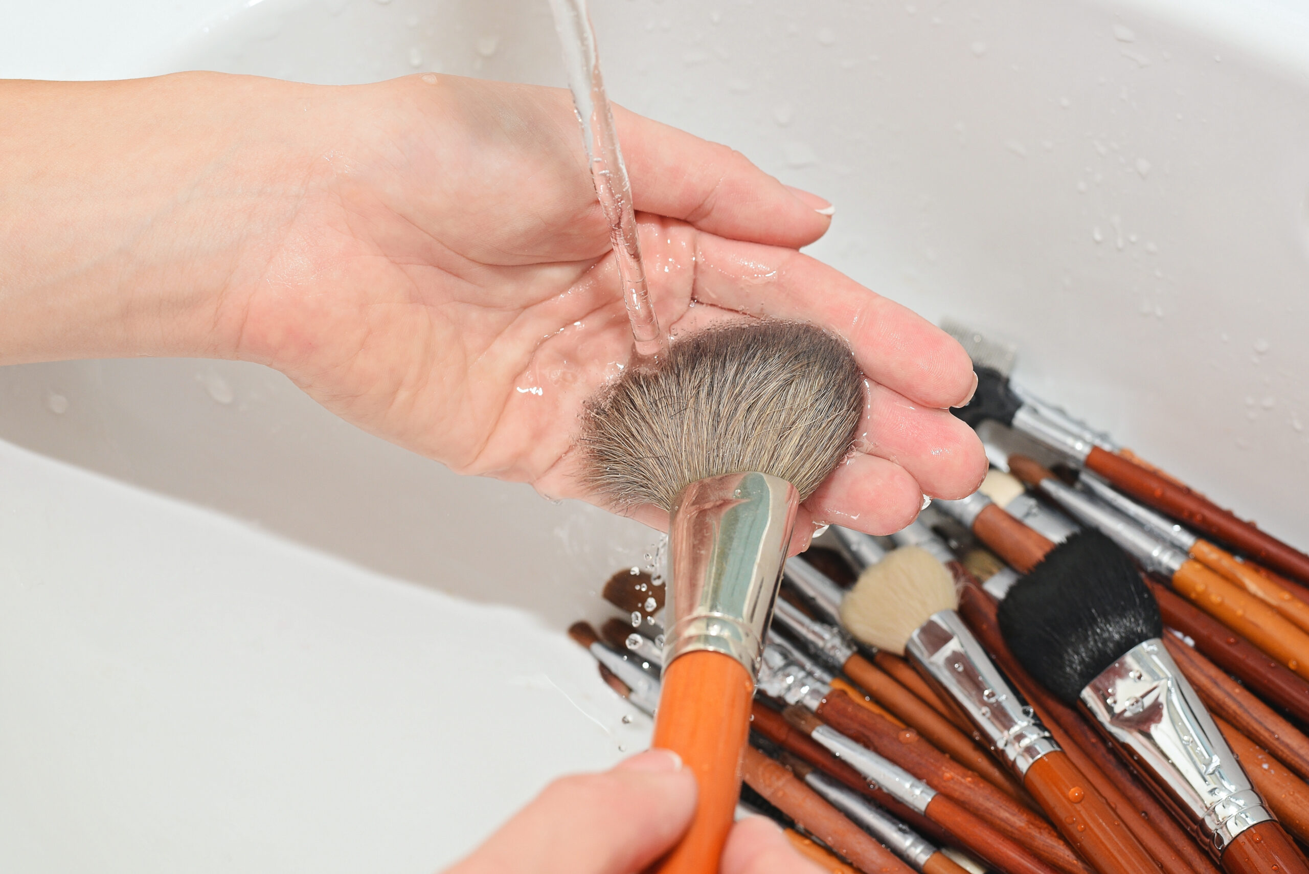 A woman cleaning her makeup brushes.