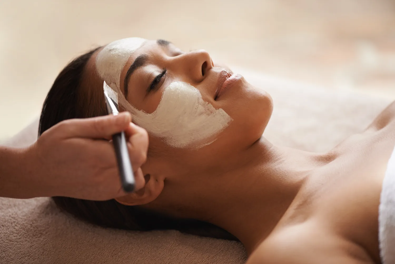 A woman getting a facial at a spa.