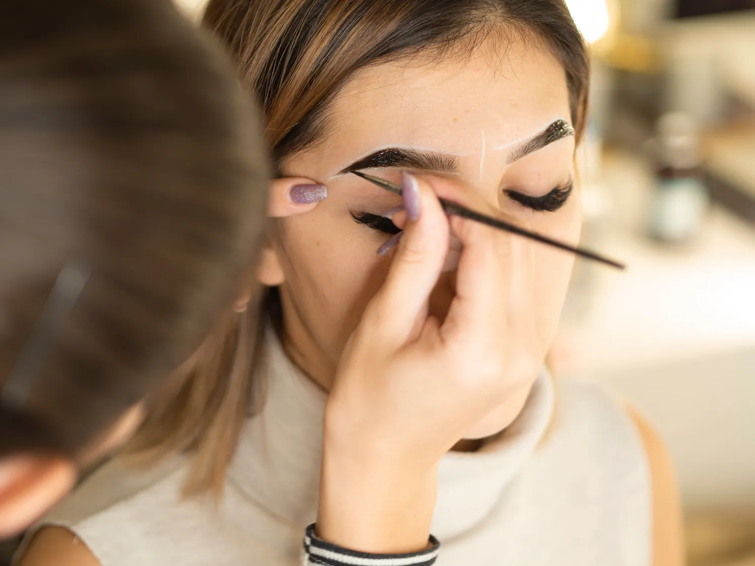 A woman getting her eyebrows tinted.